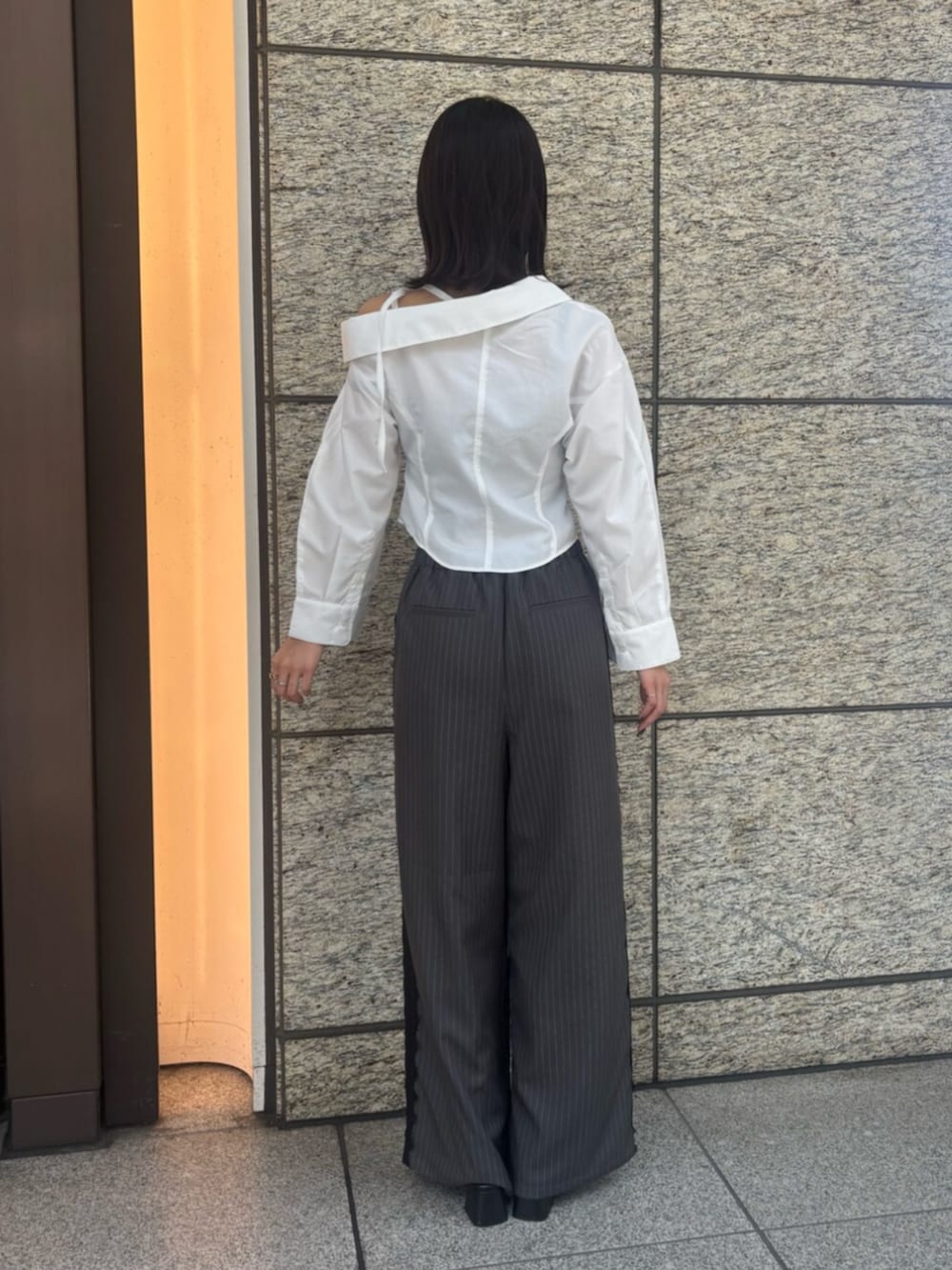 ブラック系のパンプス、グレー系のその他パンツ、ホワイト系のシャツ/ブラウスを着用したレディースの秋コーディネートの3枚目の写真
