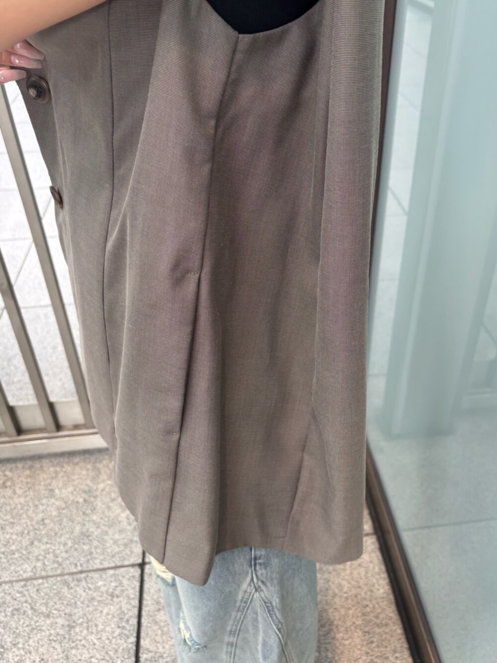 ホワイト系のサンダル、ブラック系のTシャツ/カットソー、ブラウン系のベストを着用したレディースの夏コーディネートの5枚目の写真