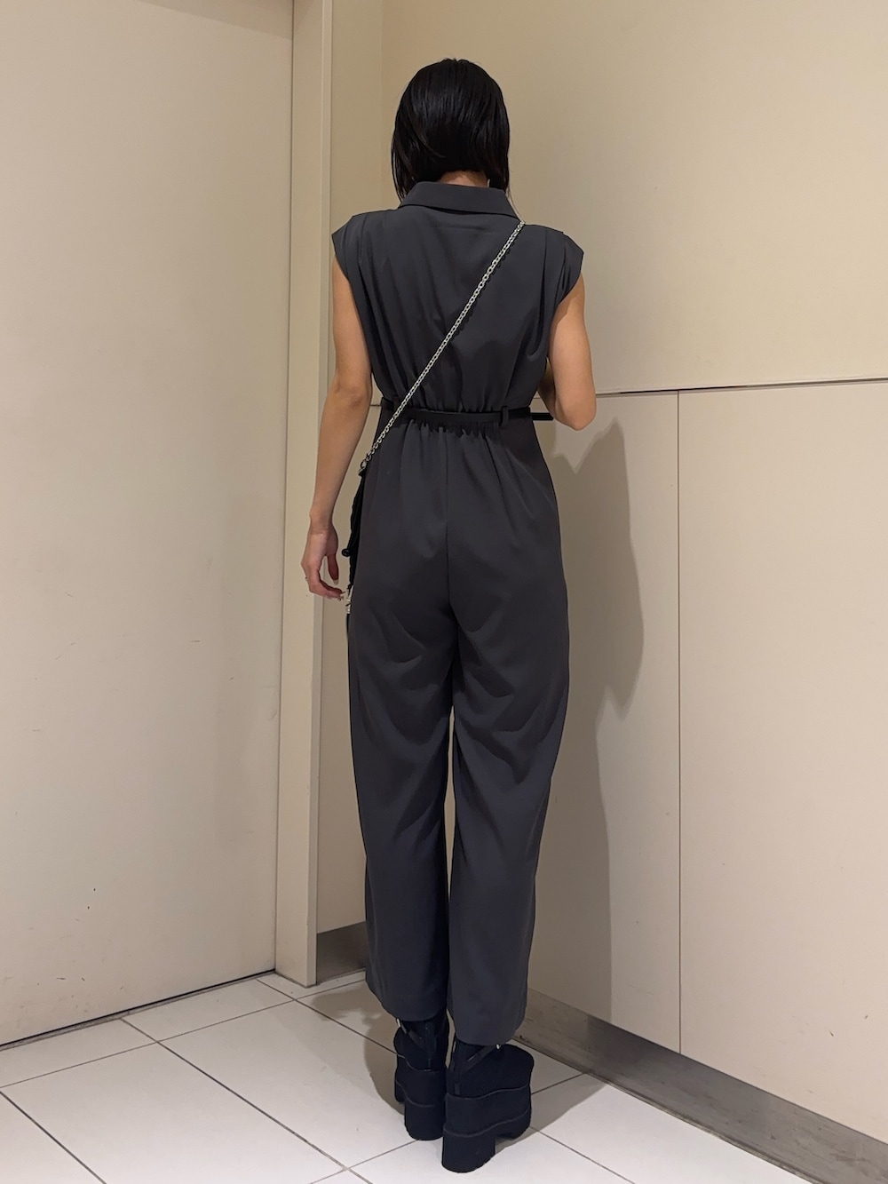 グレー系のつなぎ/オールインワン、ブラック系のブーツ、ブラック系のショルダーバッグを着用したレディースの春コーディネートの3枚目の写真