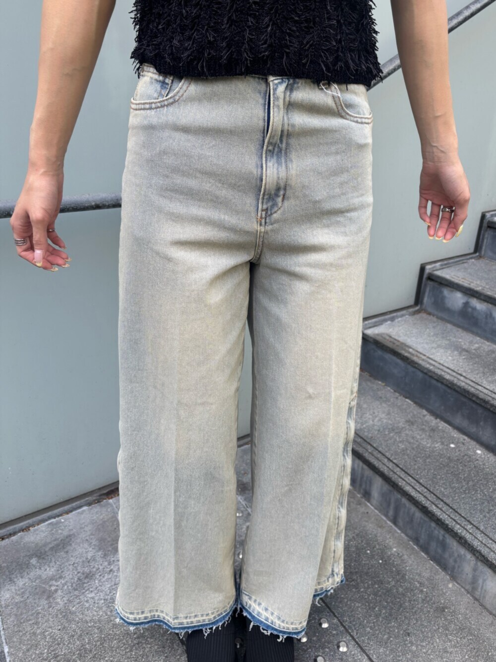 ブルー系のデニムパンツ、ブラック系のキャミソール、ブラック系のブーツを着用したレディースの春コーディネートの5枚目の写真
