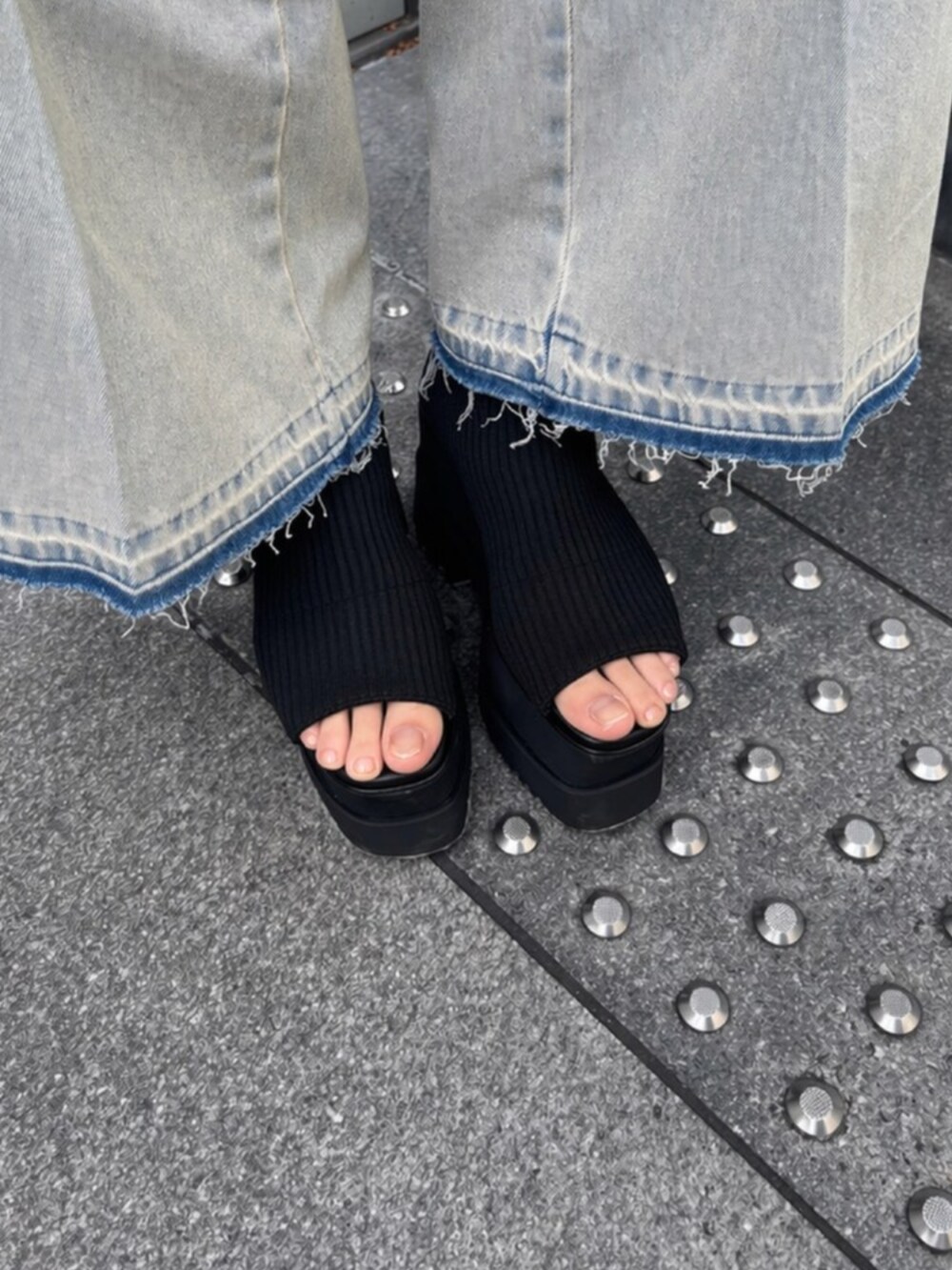 ブルー系のデニムパンツ、ブラック系のキャミソール、ブラック系のブーツを着用したレディースの春コーディネートの6枚目の写真