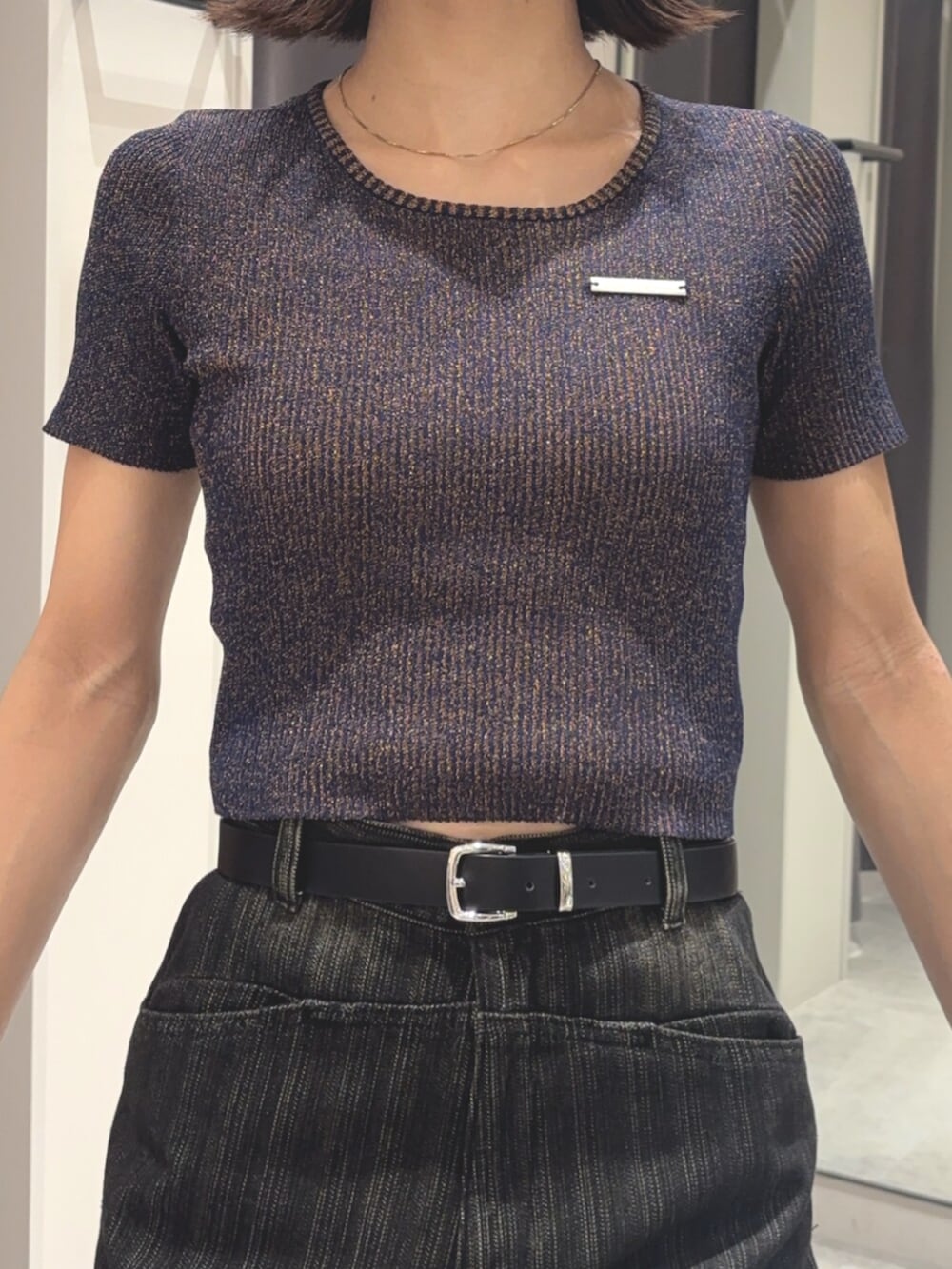 ブルー系のニット/セーター、ブラック系のデニムパンツ、ブラック系のブーツを着用したレディースの夏コーディネートの4枚目の写真