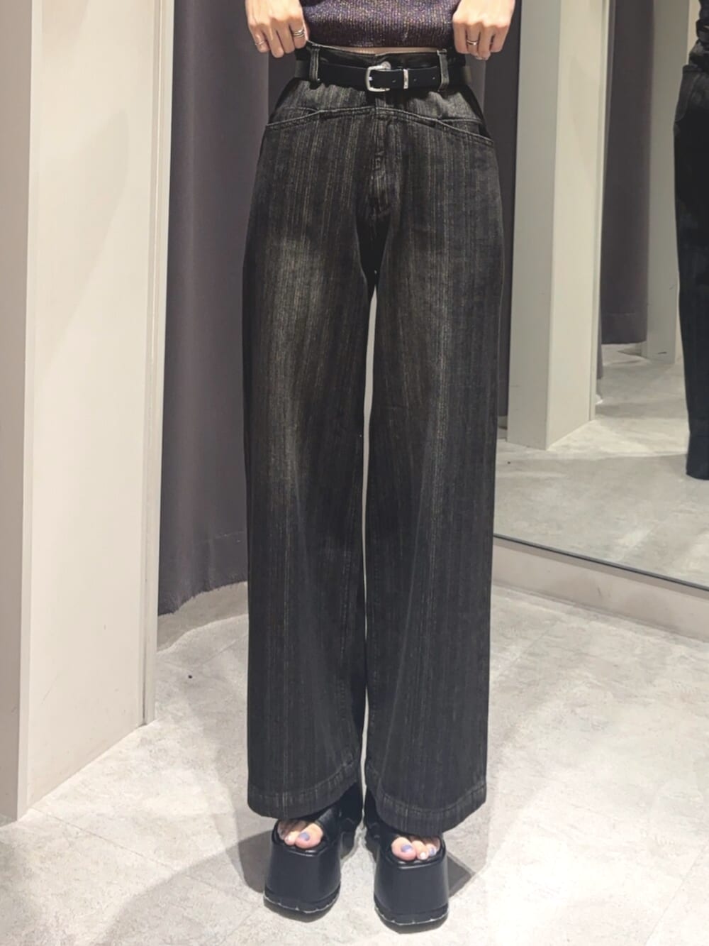 ブルー系のニット/セーター、ブラック系のデニムパンツ、ブラック系のブーツを着用したレディースの夏コーディネートの5枚目の写真