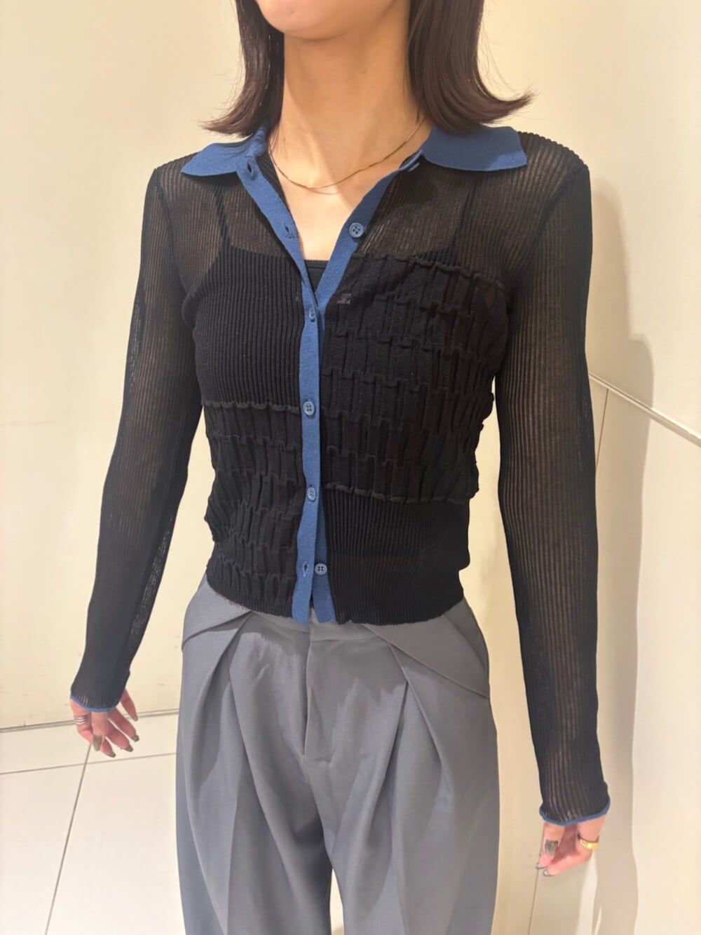 グレー系のスラックス、ブラック系のニット/セーター、ブラック系のパンプスを着用したレディースの秋コーディネートの5枚目の写真