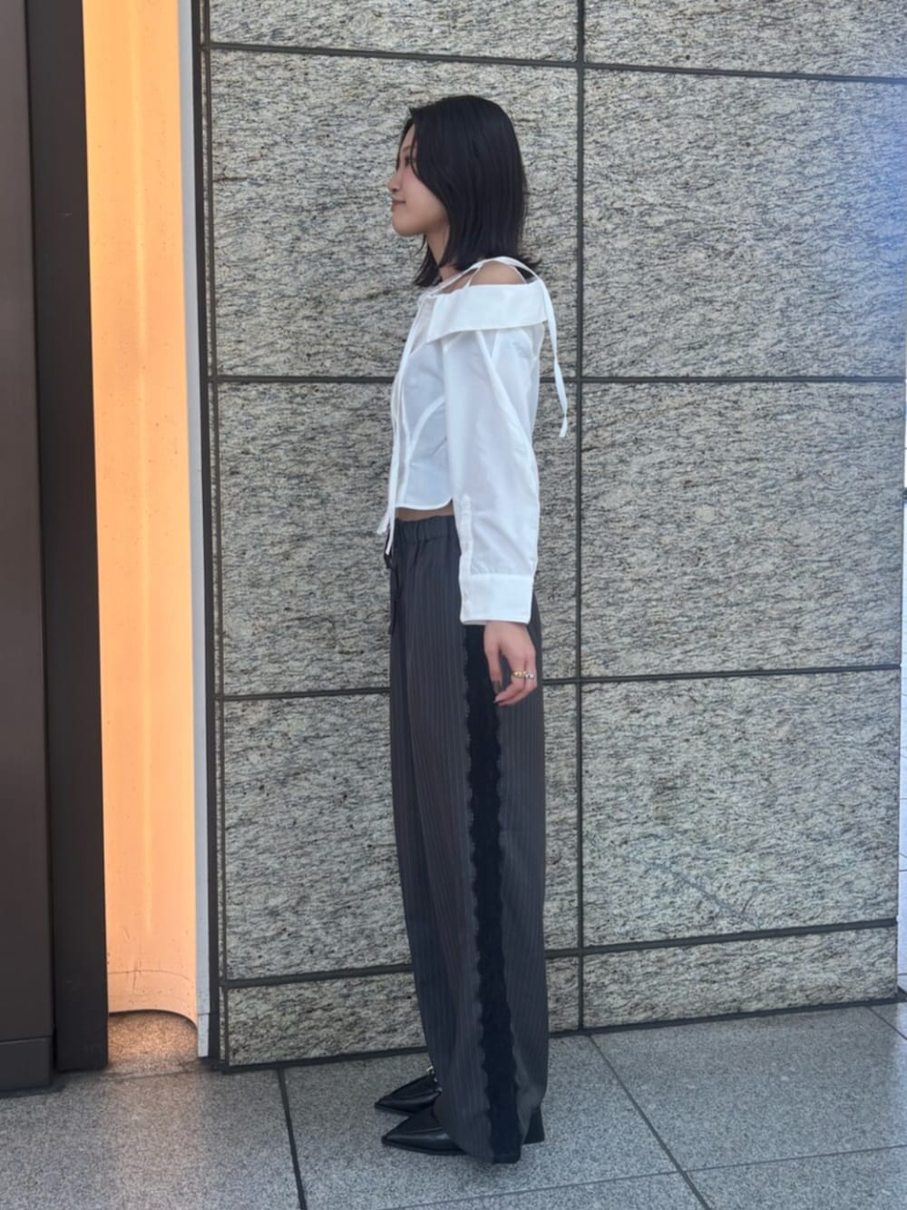 ブラック系のパンプス、グレー系のその他パンツ、ホワイト系のシャツ/ブラウスを着用したレディースの秋コーディネートの2枚目の写真