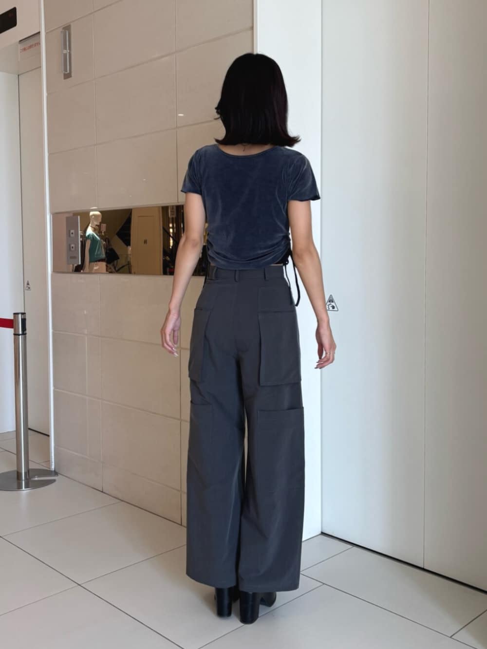 ブラック系のサンダル、グレー系のスラックス、ブルー系のTシャツ/カットソーを着用したレディースの夏コーディネートの3枚目の写真