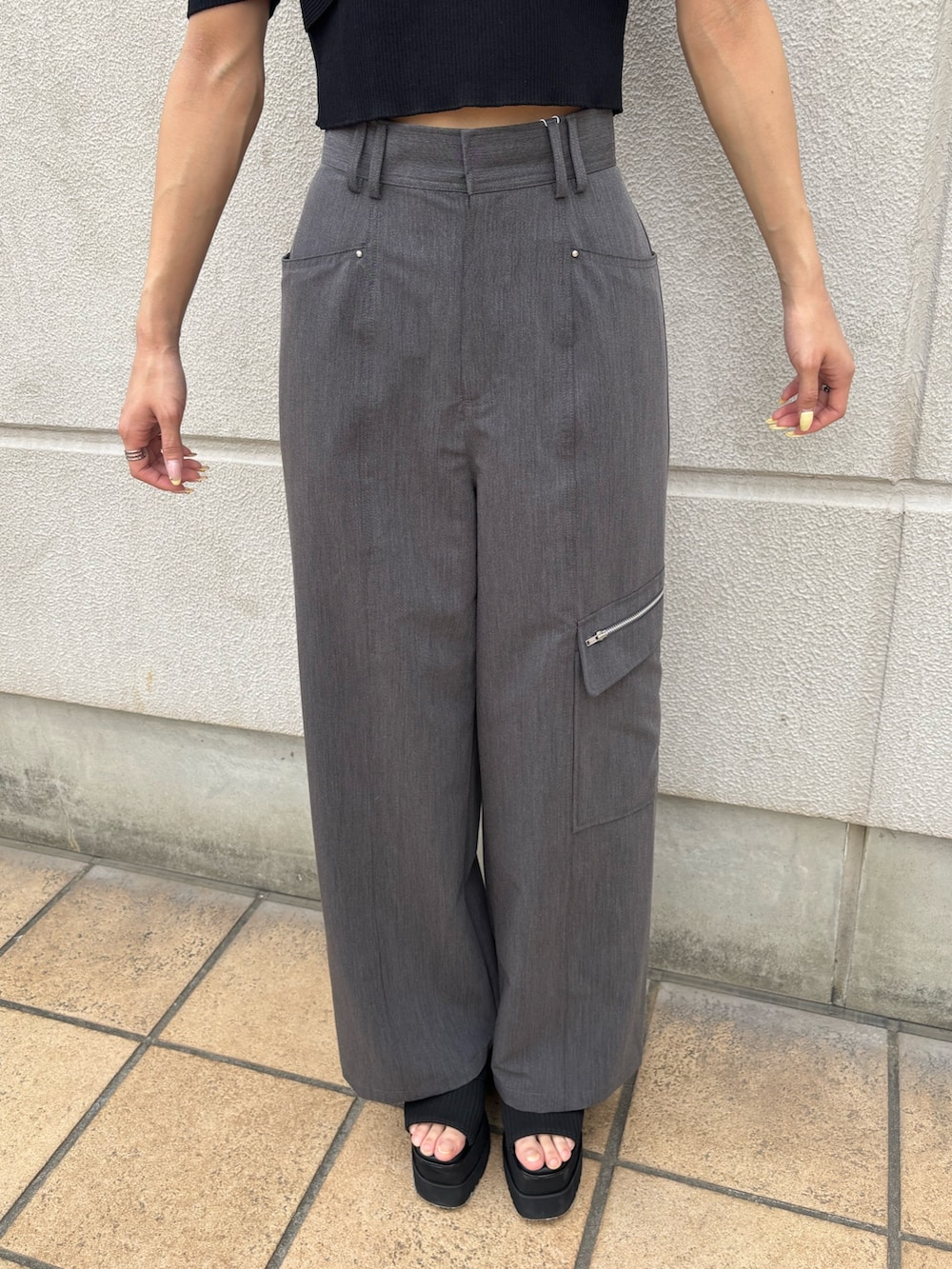 グレー系のスラックス、ブラック系のニット/セーター、ブラック系のブーツを着用したレディースの春コーディネートの5枚目の写真
