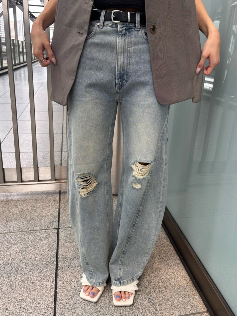 ホワイト系のサンダル、ブラック系のTシャツ/カットソー、ブラウン系のベストを着用したレディースの夏コーディネートの6枚目の写真