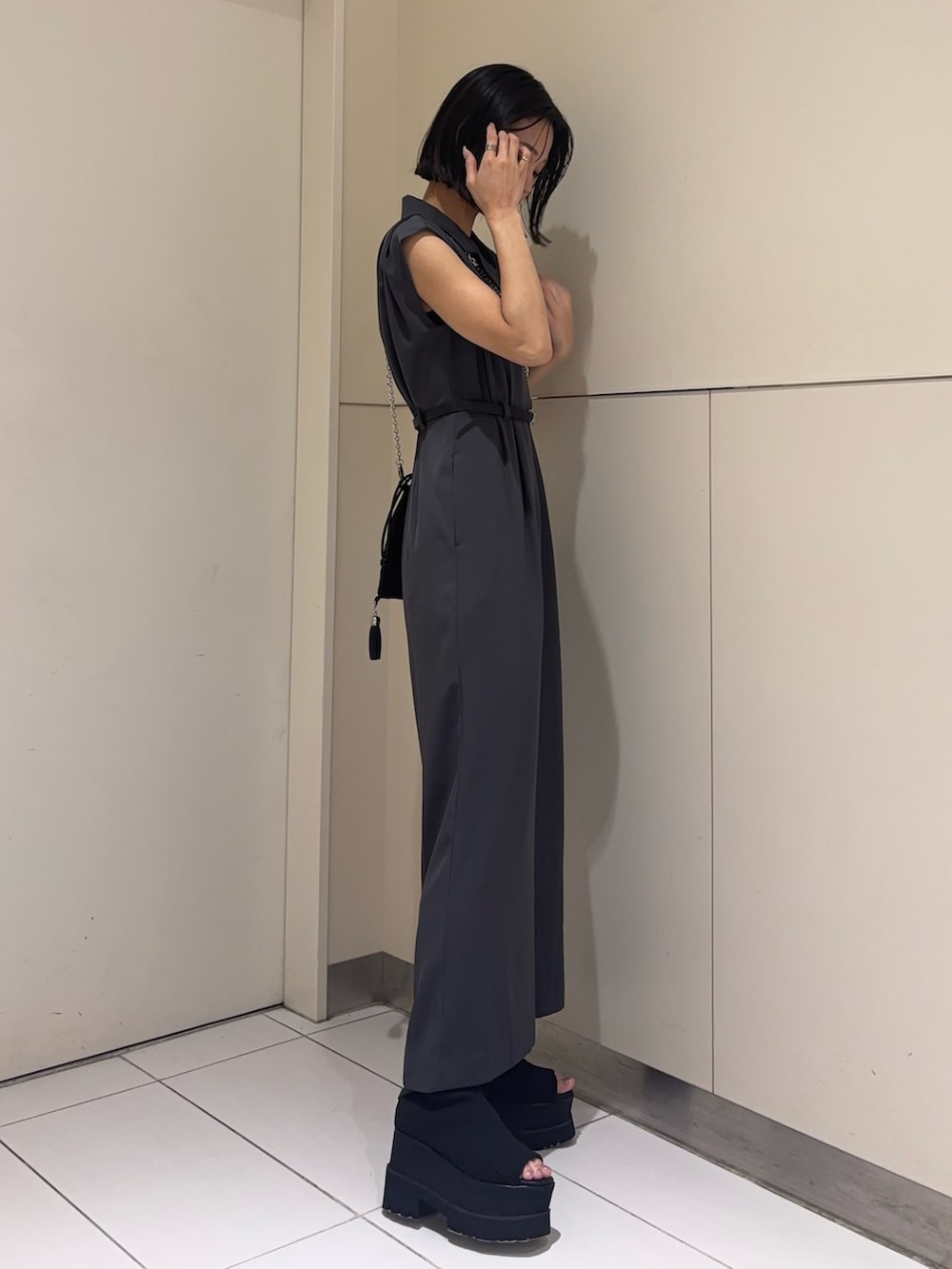グレー系のつなぎ/オールインワン、ブラック系のブーツ、ブラック系のショルダーバッグを着用したレディースの春コーディネートの2枚目の写真