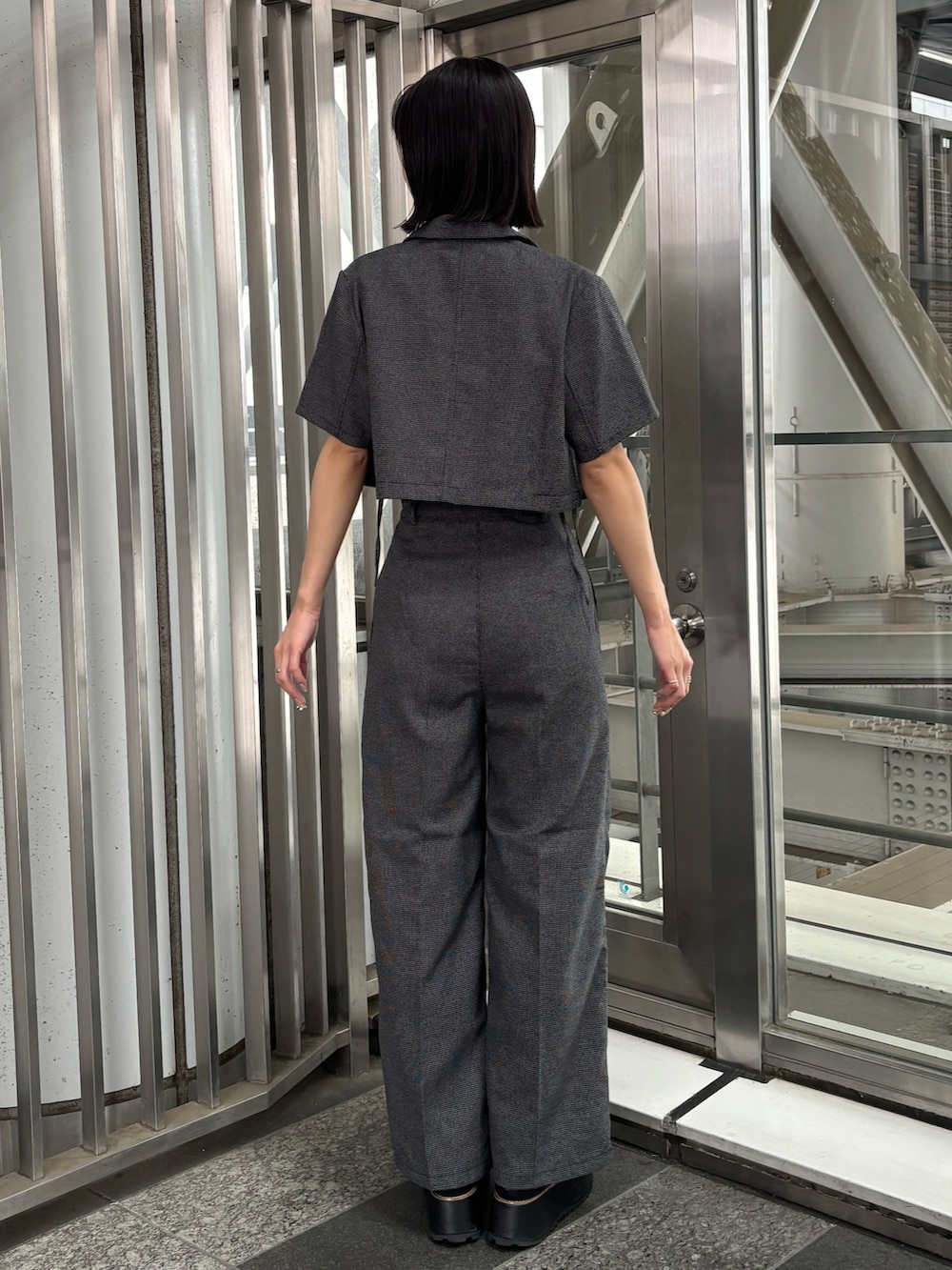 グレー系のテーラードジャケット、グレー系のタンクトップ、グレー系のその他パンツを着用したレディースの春コーディネートの3枚目の写真