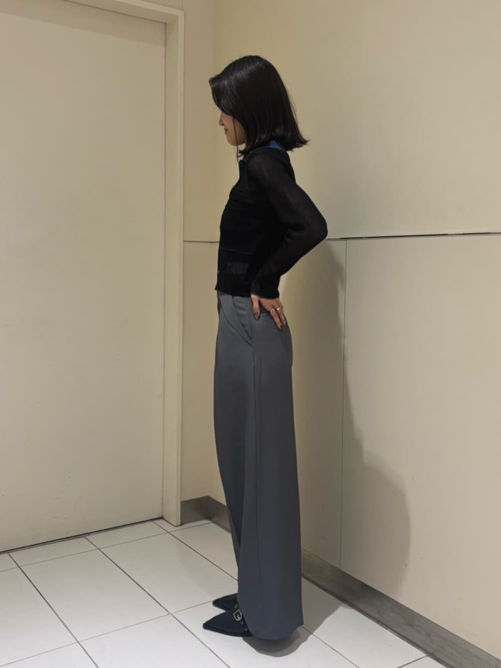 グレー系のスラックス、ブラック系のニット/セーター、ブラック系のパンプスを着用したレディースの秋コーディネートの3枚目の写真