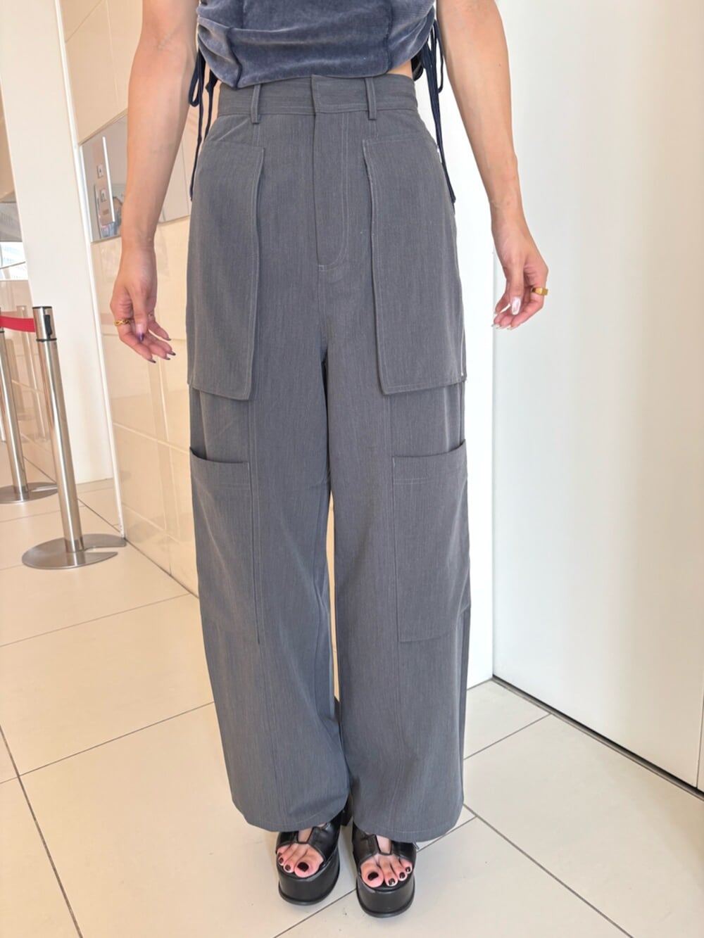 ブラック系のサンダル、グレー系のスラックス、ブルー系のTシャツ/カットソーを着用したレディースの夏コーディネートの5枚目の写真