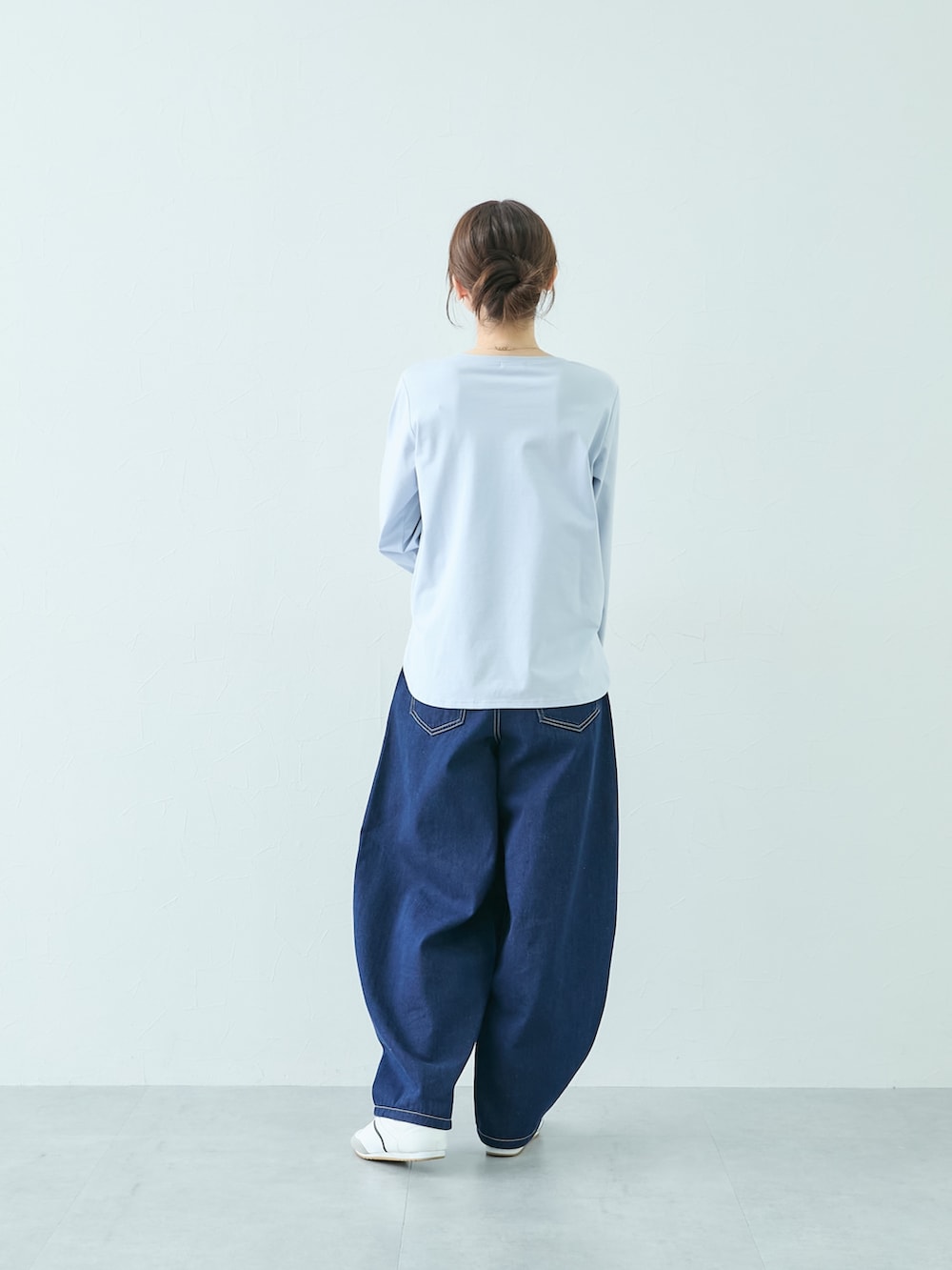 ホワイト系のニット/セーター、ブルー系のTシャツ/カットソー、ブルー系のパンツを着用したレディースの秋コーディネートの5枚目の写真