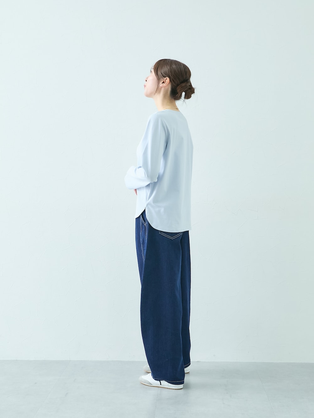 ホワイト系のニット/セーター、ブルー系のTシャツ/カットソー、ブルー系のパンツを着用したレディースの秋コーディネートの4枚目の写真