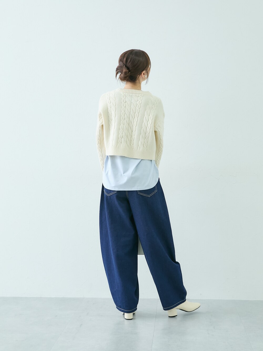 ホワイト系のニット/セーター、ブルー系のTシャツ/カットソー、ブルー系のパンツを着用したレディースの秋コーディネートの2枚目の写真