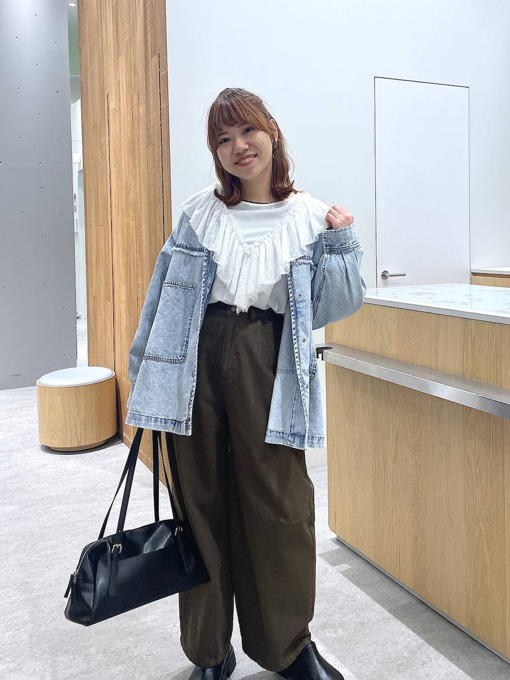 ブラック系のボストンバッグ、ブラック系のその他シューズ、グリーン系のその他パンツを着用したレディースの冬コーディネートの4枚目の写真