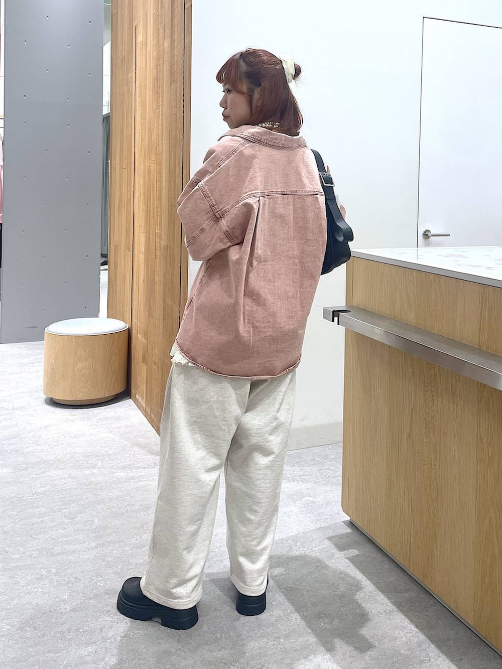 ピンク系のシャツ/ブラウス、ブラック系のショルダーバッグ、グレー系のスウェットパンツを着用したレディースの冬コーディネートの4枚目の写真