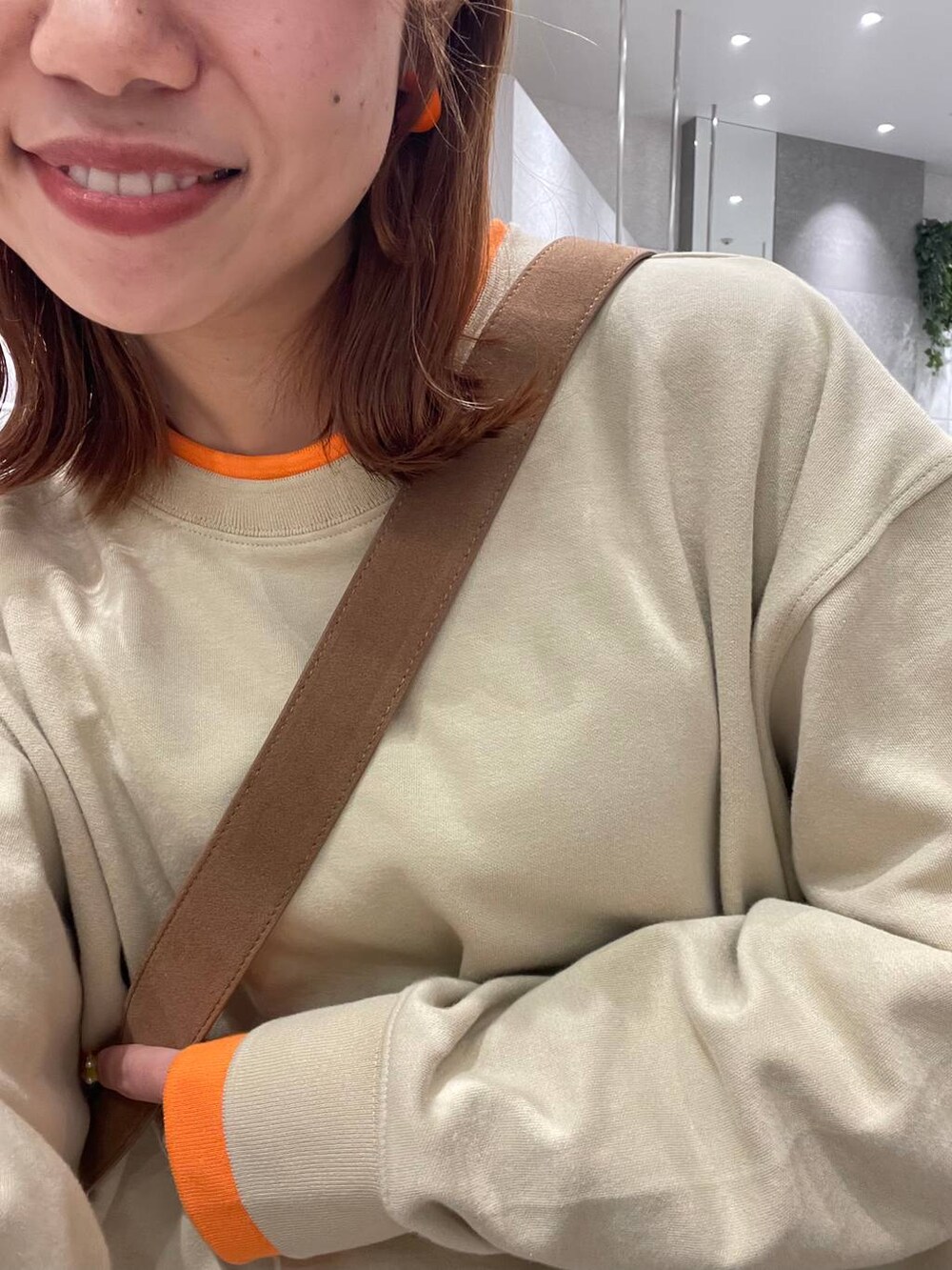 ブラウン系のショルダーバッグ、ベージュ系のその他パンツ、ホワイト系のスニーカーを着用したレディースの冬コーディネートの5枚目の写真