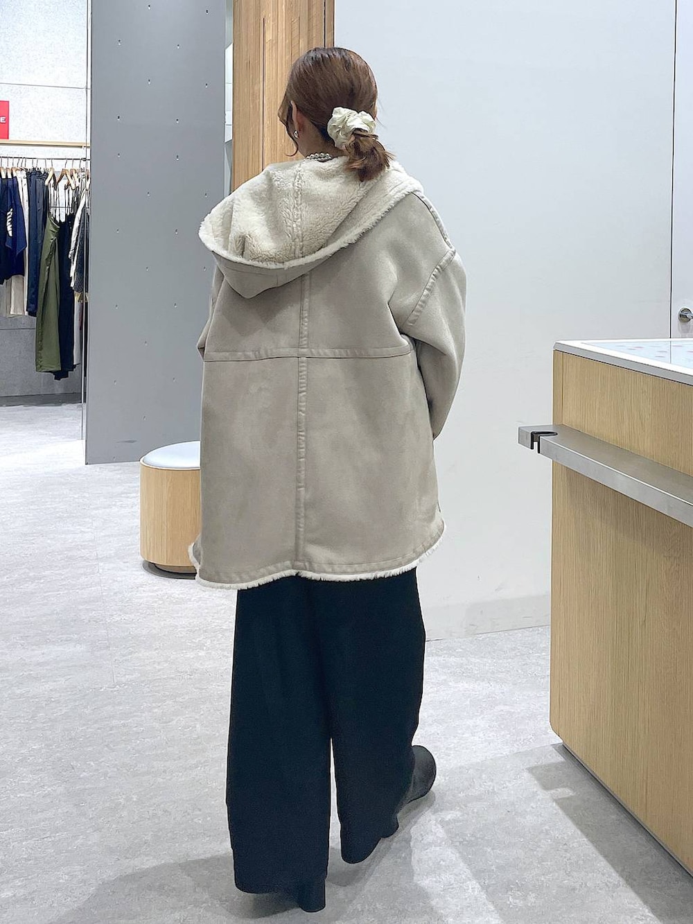 レッド系のニット/セーター、ブラック系のブーツ、ホワイト系のショルダーバッグを着用したレディースの冬コーディネートの3枚目の写真