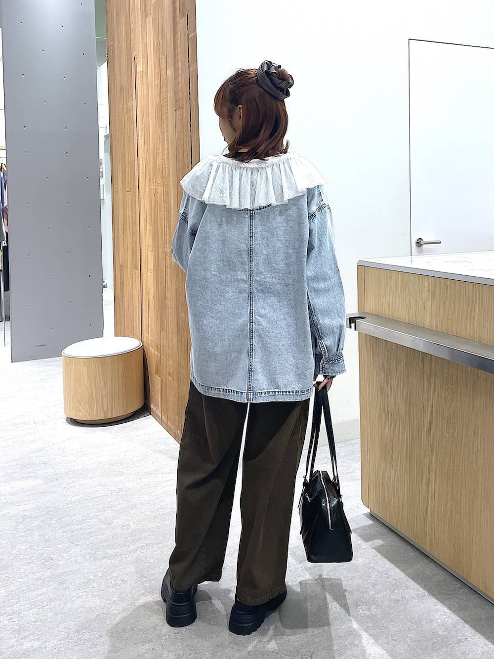 ブラック系のボストンバッグ、ブラック系のその他シューズ、グリーン系のその他パンツを着用したレディースの冬コーディネートの3枚目の写真