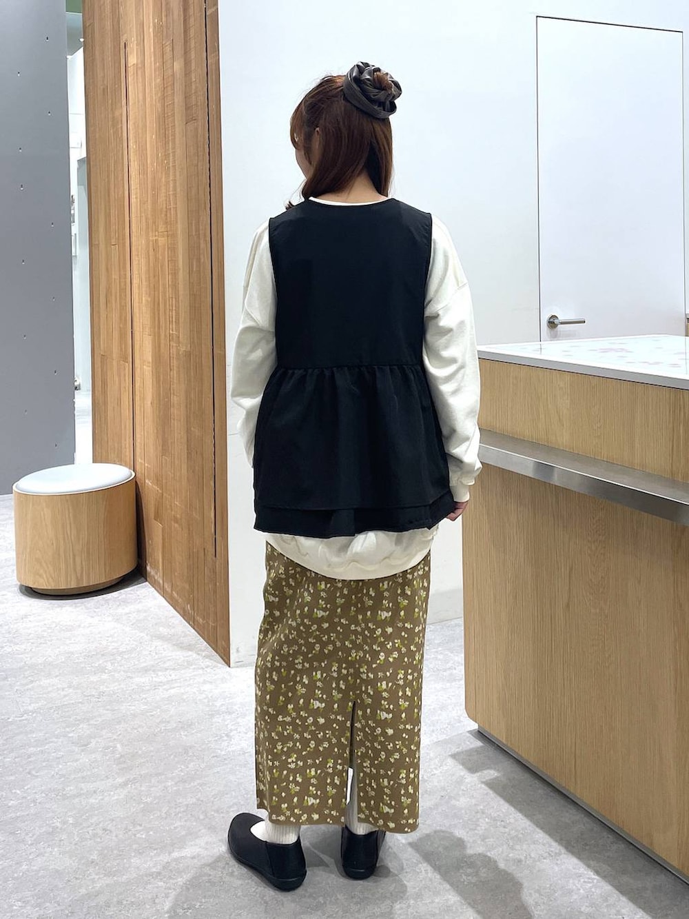 ホワイト系のスウェット、ブラック系のパンプス、ブラウン系のスカートを着用したレディースの冬コーディネートの3枚目の写真