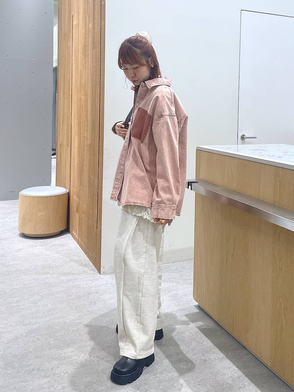 ピンク系のシャツ/ブラウス、ブラック系のショルダーバッグ、グレー系のスウェットパンツを着用したレディースの冬コーディネートの2枚目の写真