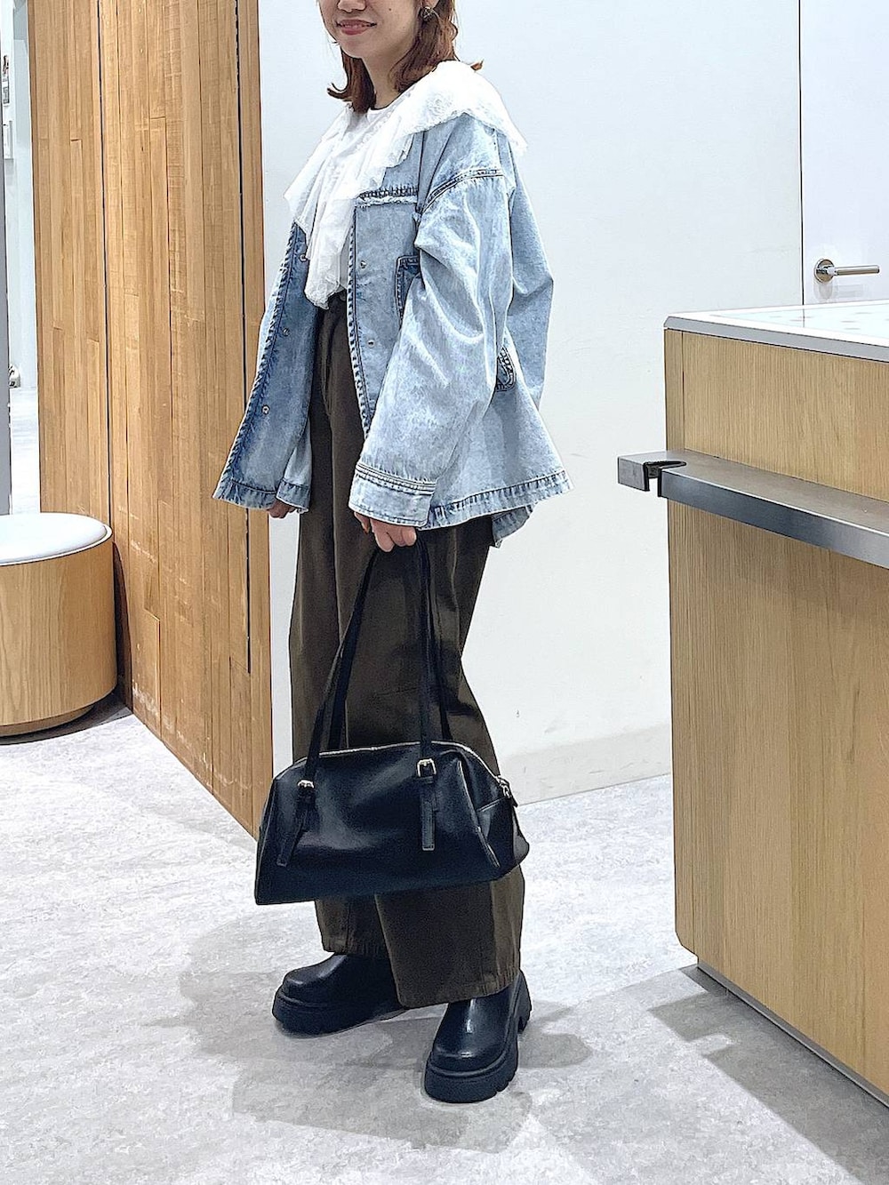 ブラック系のボストンバッグ、ブラック系のその他シューズ、グリーン系のその他パンツを着用したレディースの冬コーディネートの2枚目の写真