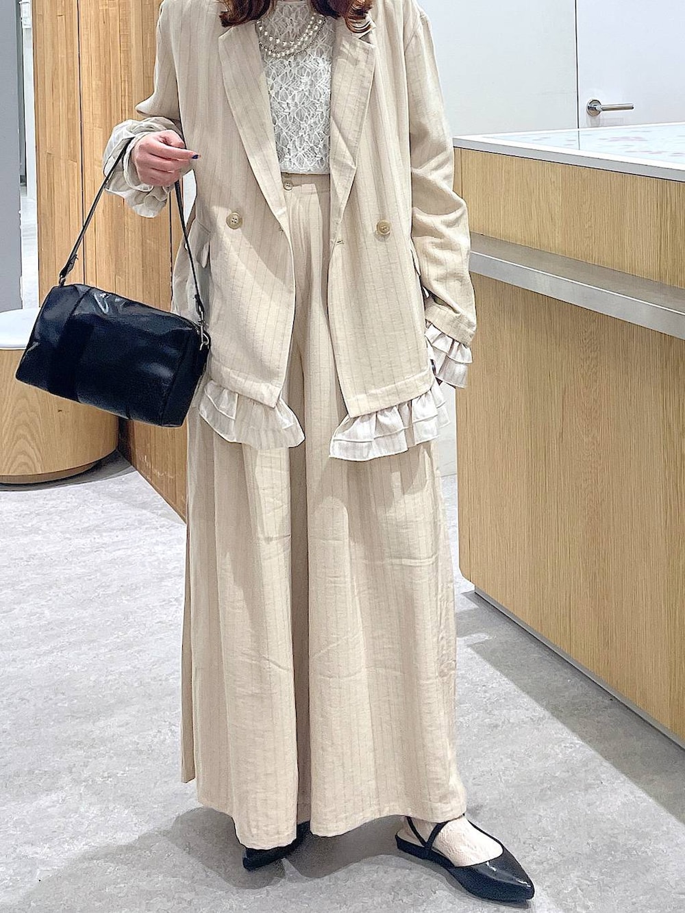 ベージュ系のその他パンツ、ベージュ系のテーラードジャケット、ブラック系のショルダーバッグを着用したレディースの春コーディネートの4枚目の写真