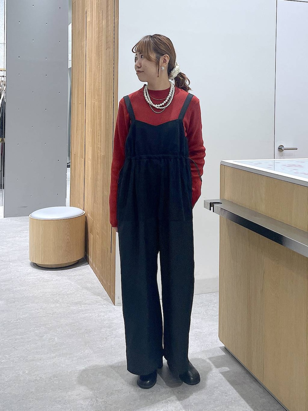 レッド系のニット/セーター、ブラック系のブーツ、ホワイト系のショルダーバッグを着用したレディースの冬コーディネートの4枚目の写真