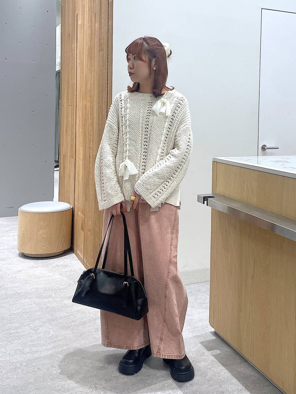 ブラック系のボストンバッグ、ピンク系のデニムパンツ、ブラック系のその他シューズを着用したレディースの冬コーディネートの4枚目の写真