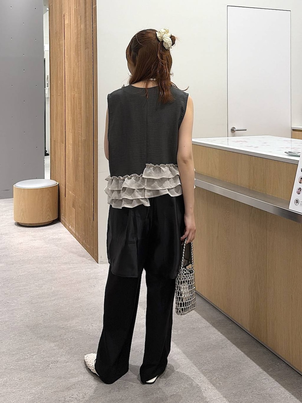 シルバー系のショルダーバッグ、ホワイト系のタンクトップ、ホワイト系のパンプスを着用したレディースの春コーディネートの3枚目の写真