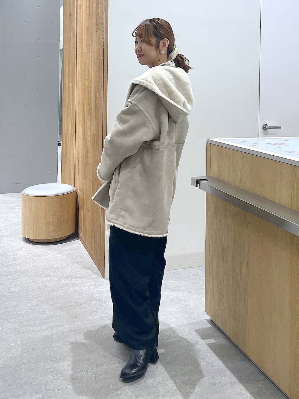 レッド系のニット/セーター、ブラック系のブーツ、ホワイト系のショルダーバッグを着用したレディースの冬コーディネートの2枚目の写真