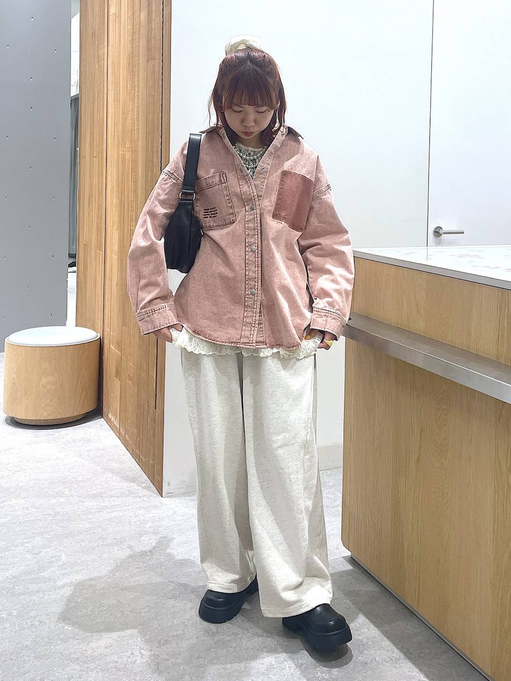 ピンク系のシャツ/ブラウス、ブラック系のショルダーバッグ、グレー系のスウェットパンツを着用したレディースの冬コーディネートの3枚目の写真