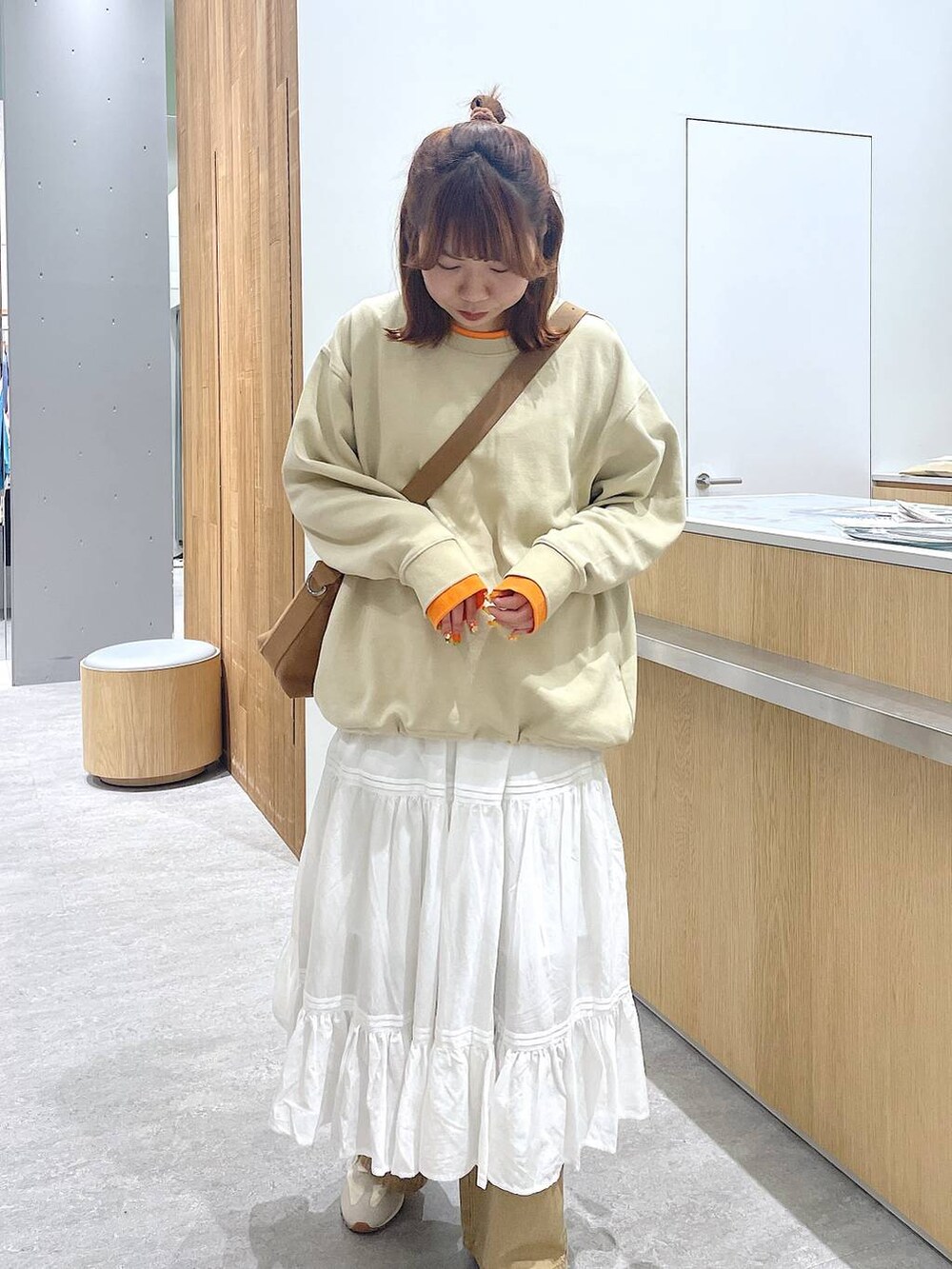 ブラウン系のショルダーバッグ、ベージュ系のその他パンツ、ホワイト系のスニーカーを着用したレディースの冬コーディネートの4枚目の写真