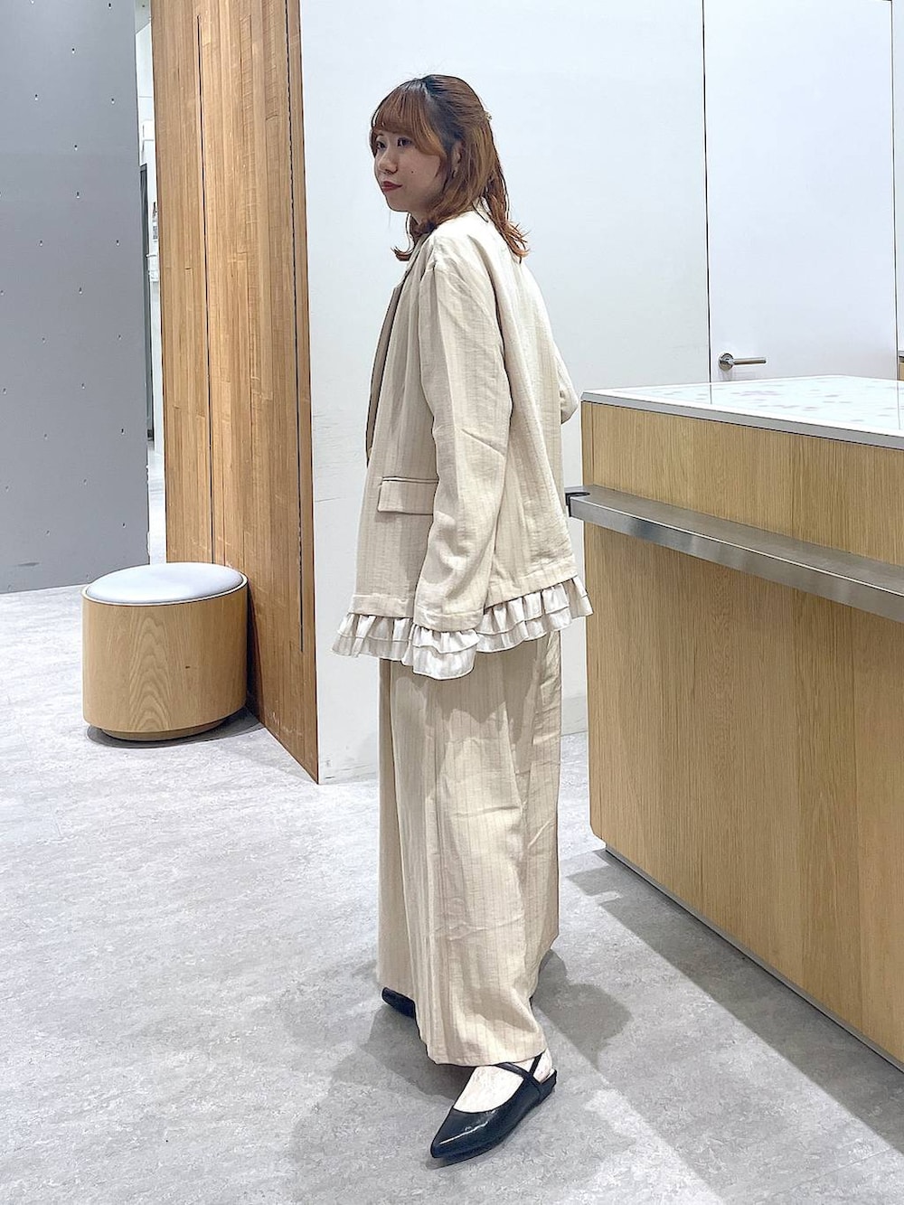 ベージュ系のその他パンツ、ベージュ系のテーラードジャケット、ブラック系のショルダーバッグを着用したレディースの春コーディネートの2枚目の写真