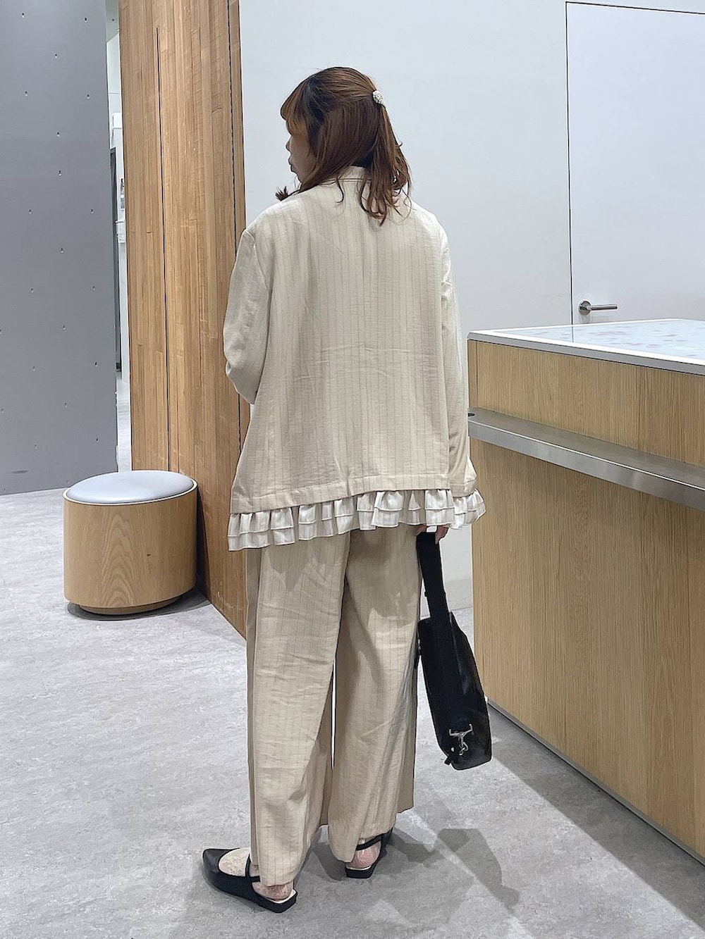 ベージュ系のその他パンツ、ベージュ系のテーラードジャケット、ブラック系のショルダーバッグを着用したレディースの春コーディネートの3枚目の写真