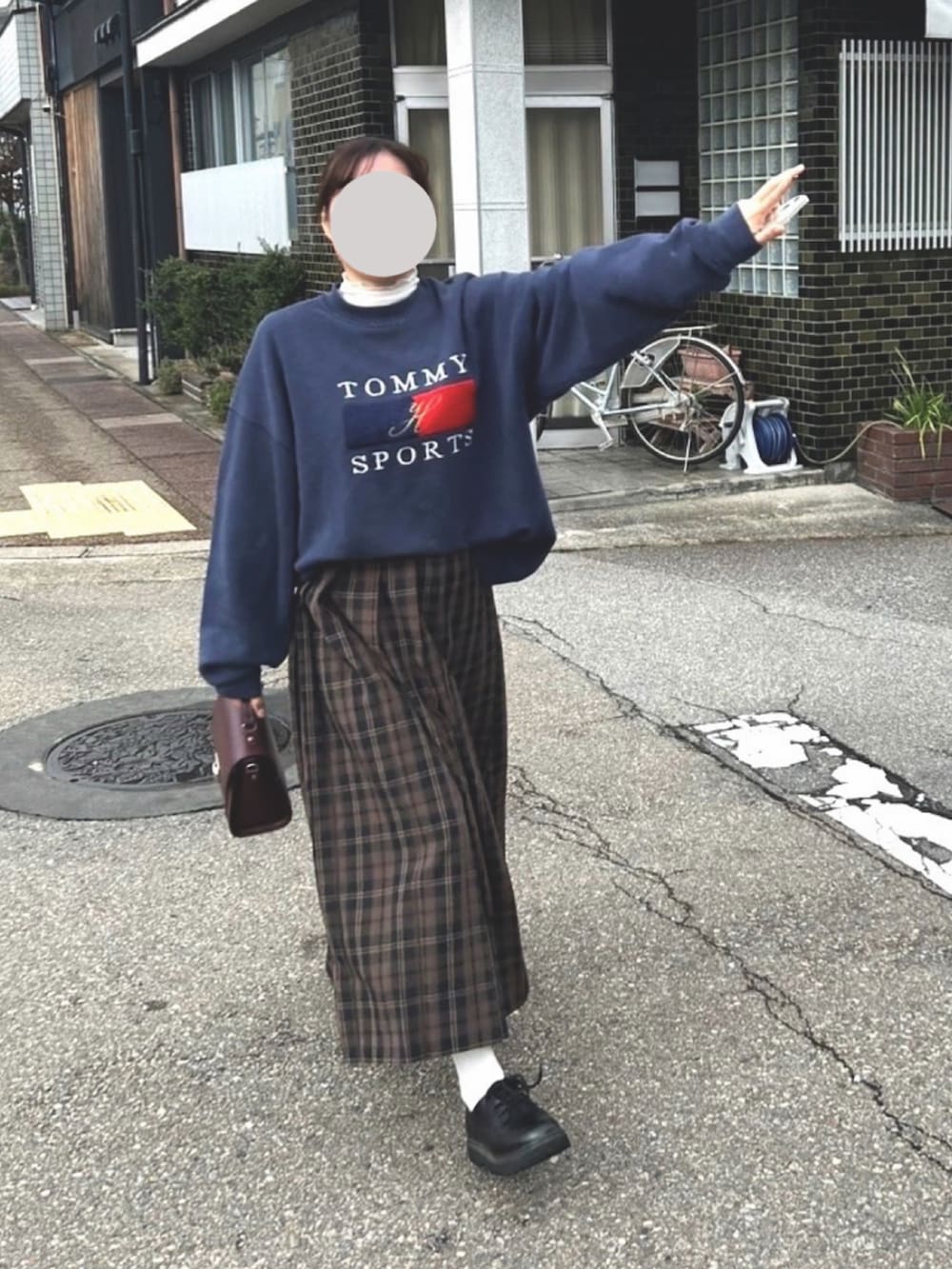 ブラウン系のスカート、ブルー系のスウェット、レッド系のハンドバッグを着用したレディースの秋コーディネートの2枚目の写真