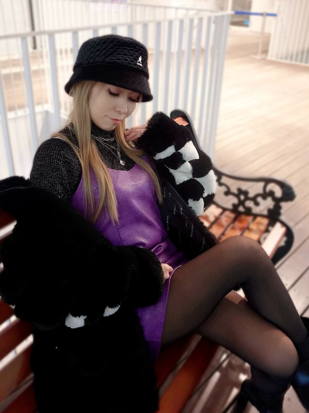 ブラック系のニット/セーター、パープル系のワンピース、ブラック系のブーツを着用したレディースの秋コーディネートの2枚目の写真