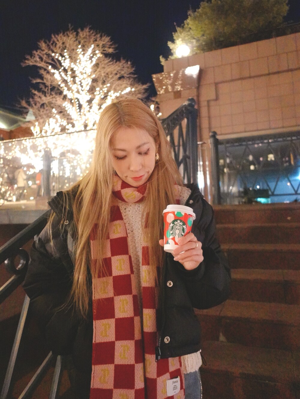 ブルー系のデニムパンツ、ブラック系のダウンジャケット/コート、ホワイト系のニット/セーターを着用したレディースの冬コーディネートの3枚目の写真