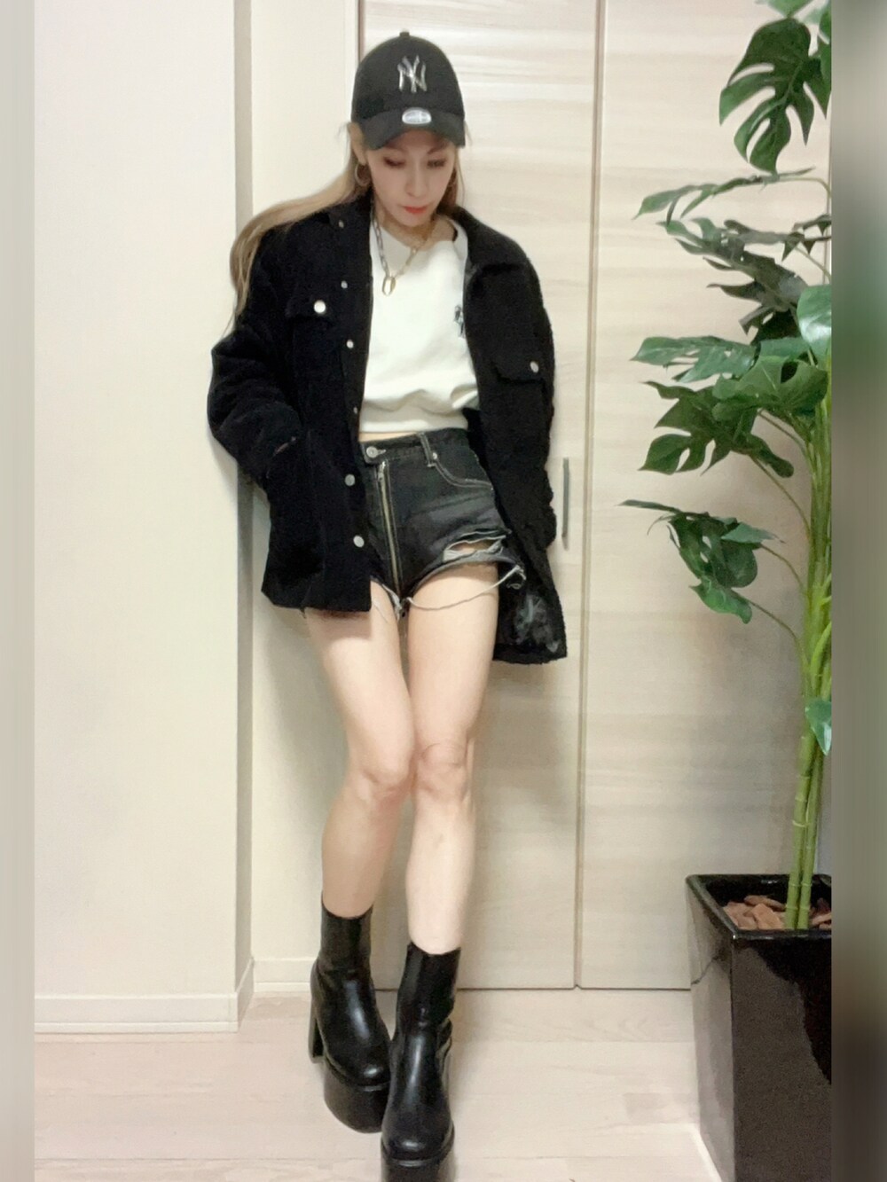 ブラック系のダウンジャケット/コート、ホワイト系のスウェット、ブラック系のブーツを着用したレディースの冬コーディネートの4枚目の写真