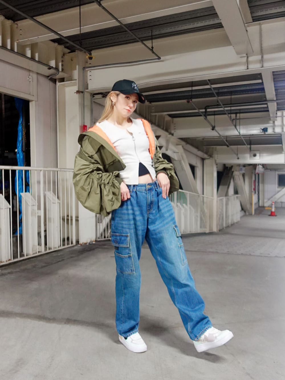ブルー系のカーゴパンツ、グリーン系のMA-1、ホワイト系のトップスを着用したレディースの秋コーディネートの2枚目の写真