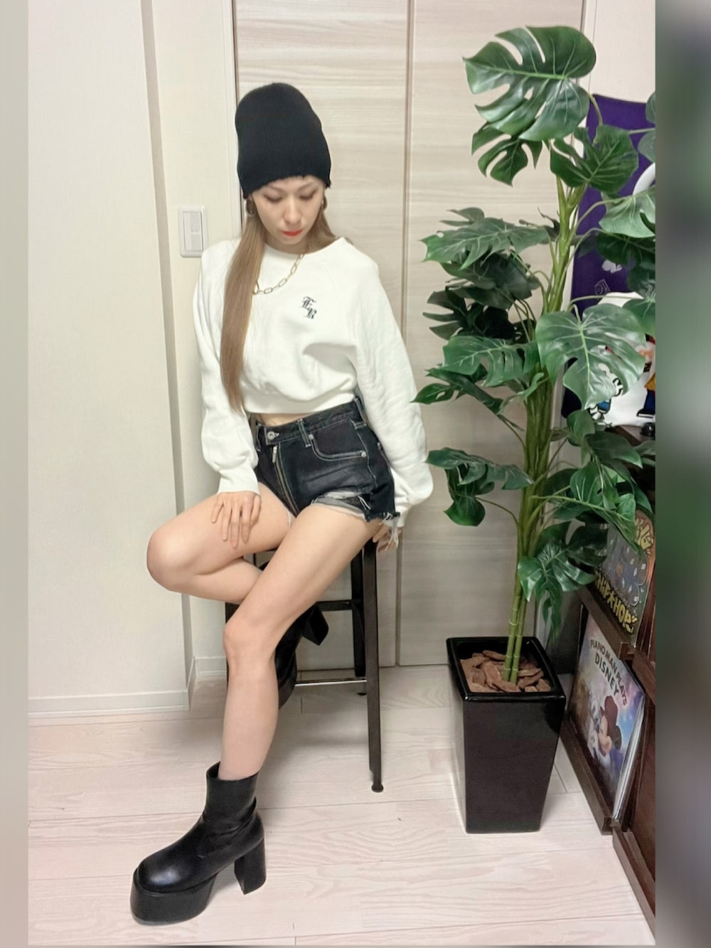 ブラック系のダウンジャケット/コート、ホワイト系のスウェット、ブラック系のブーツを着用したレディースの冬コーディネートの3枚目の写真