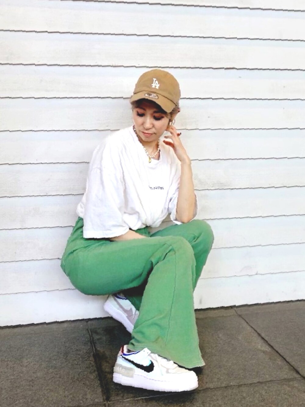 ホワイト系のTシャツ/カットソー、グリーン系のスウェットパンツ、ホワイト系のスニーカーを着用したレディースの春コーディネートの2枚目の写真