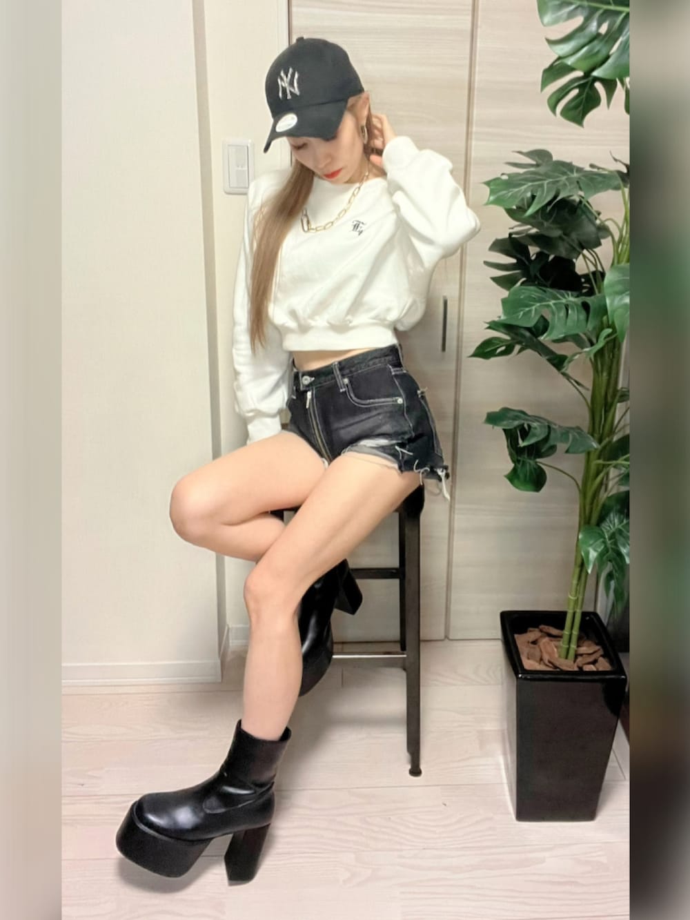 ブラック系のダウンジャケット/コート、ホワイト系のスウェット、ブラック系のブーツを着用したレディースの冬コーディネートの2枚目の写真