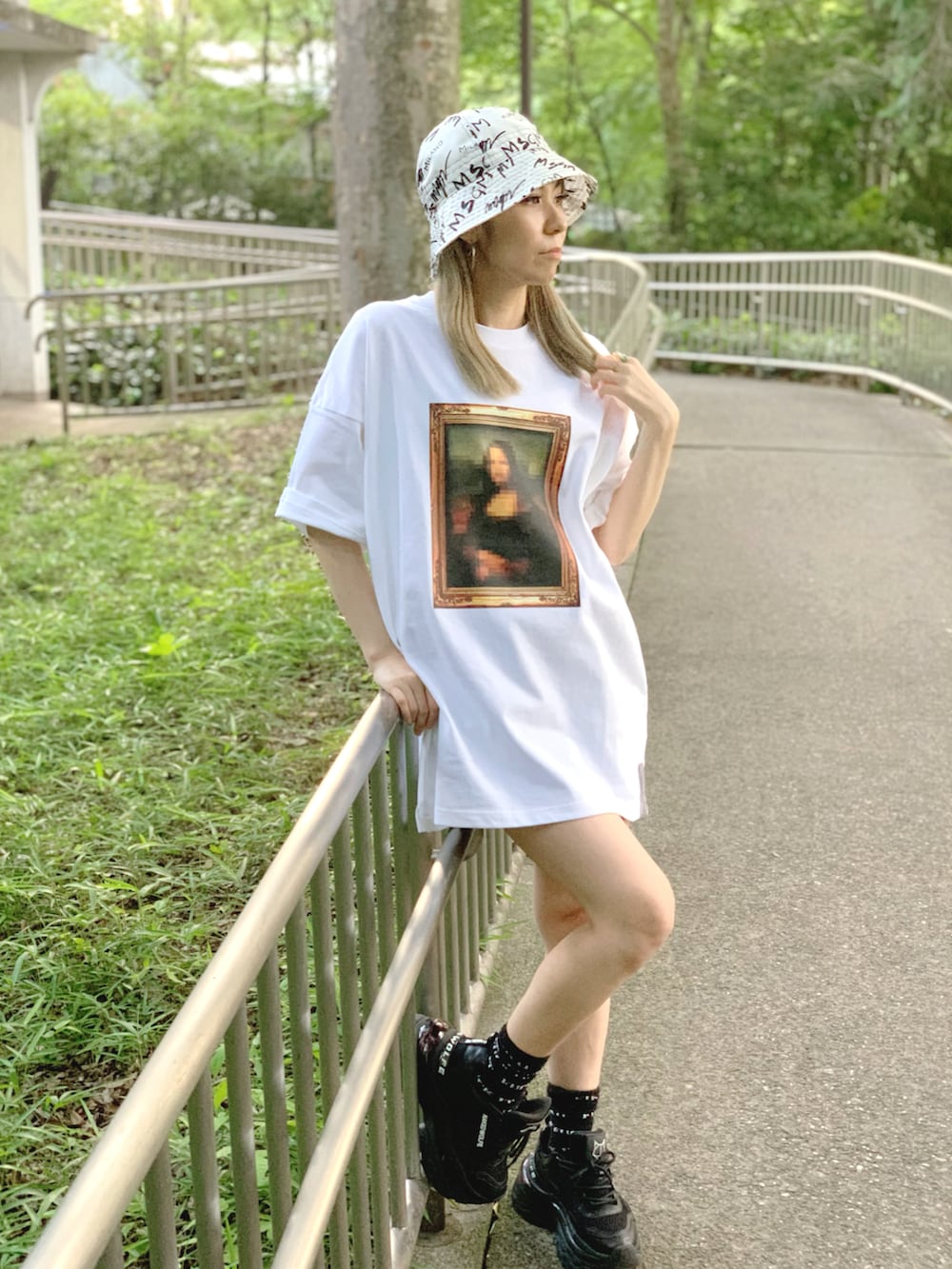 ブラック系のスニーカー、ホワイト系のTシャツ/カットソー、ホワイト系のハットを着用したレディースの春コーディネートの2枚目の写真