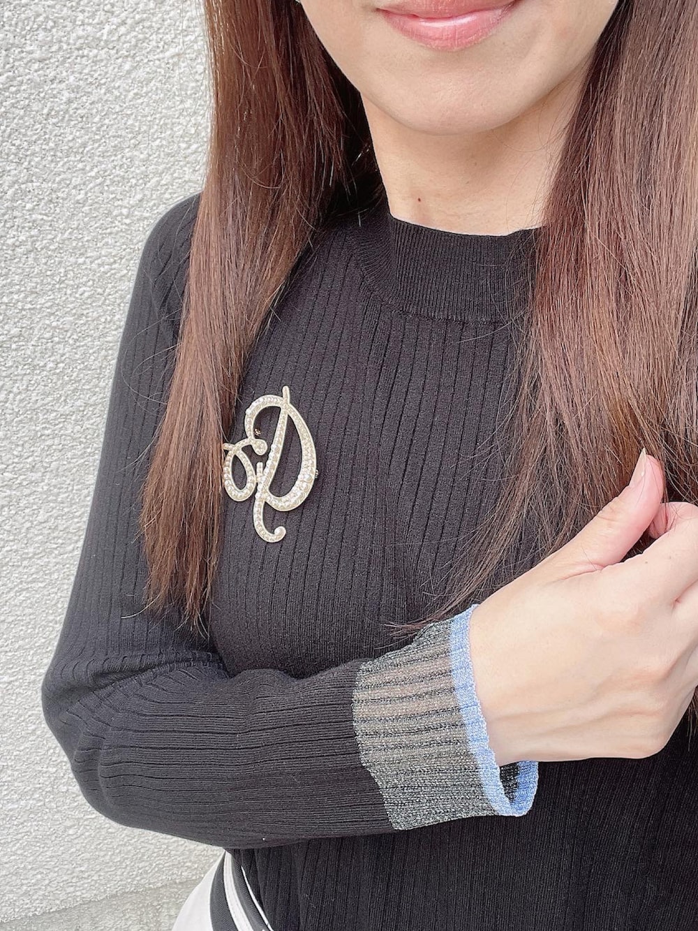 ブラック系のニット/セーター、ホワイト系のスラックス、ブラック系のパンプスを着用したレディースの秋コーディネートの4枚目の写真