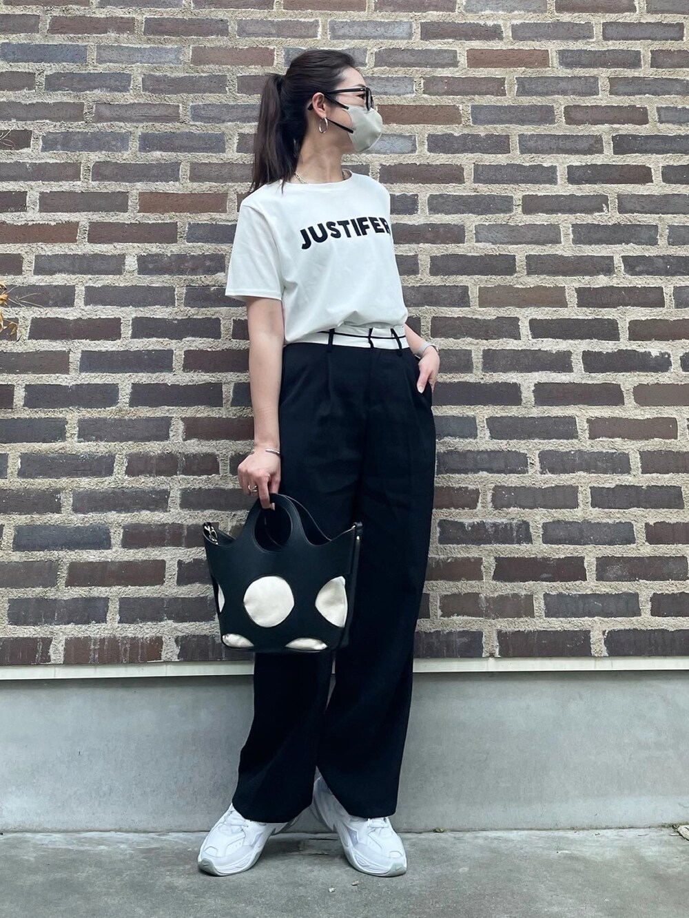 ブラック系のその他パンツ、ホワイト系のスニーカー、ホワイト系のTシャツ/カットソーを着用したレディースの春コーディネートの4枚目の写真