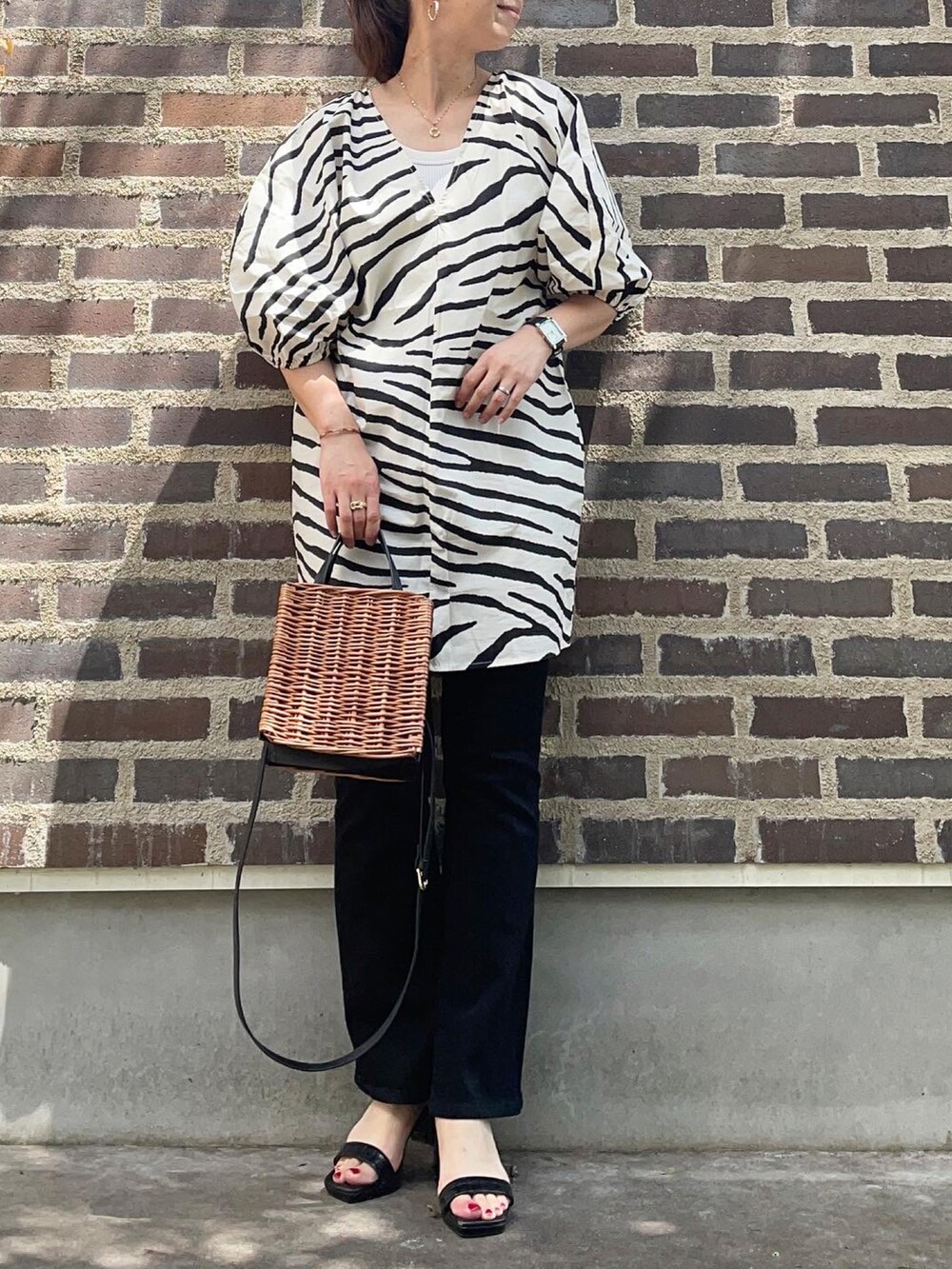 その他のチュニック、ブラック系のデニムパンツ、ブラック系のサンダルを着用したレディースの夏コーディネートの2枚目の写真