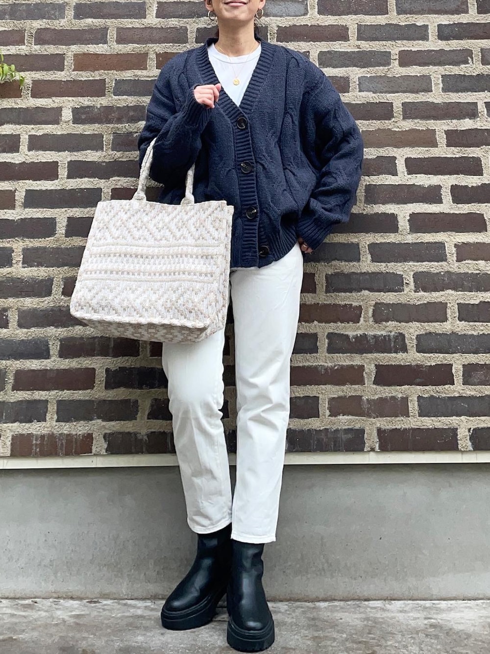 ブルー系のカーディガン/ボレロ、ホワイト系のデニムパンツ、ブラック系のブーツを着用したレディースの秋コーディネートの2枚目の写真