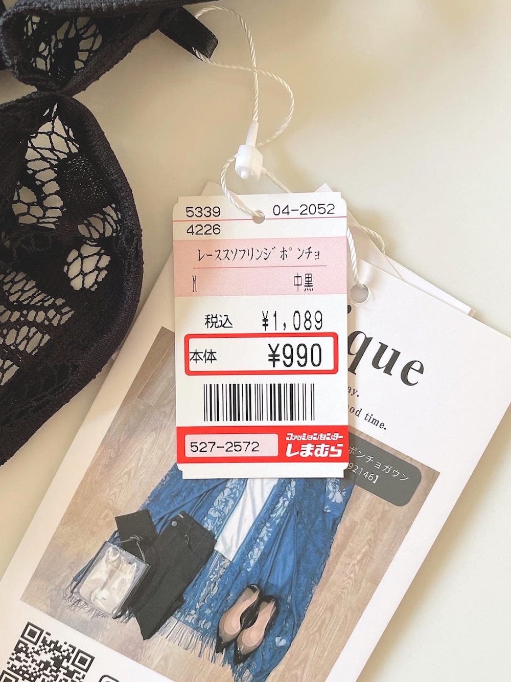 ホワイト系のタンクトップ、ブラック系のポンチョ、ブルー系のデニムパンツを着用したレディースの春コーディネートの5枚目の写真